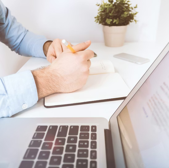 person writing on white notebook