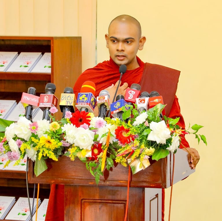 a monk in a red robe speaking into a microphone