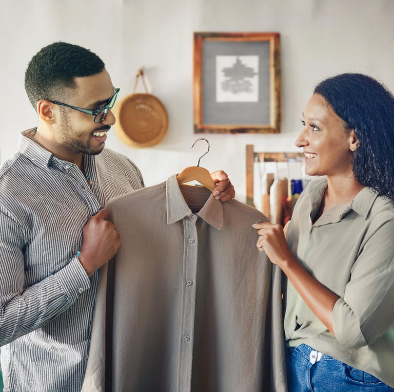 a man and woman looking at each other while holding a hanger