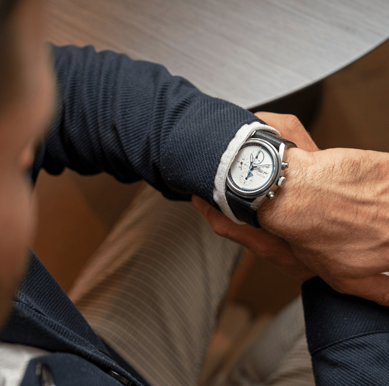 a man in a suit and tie is holding a watch