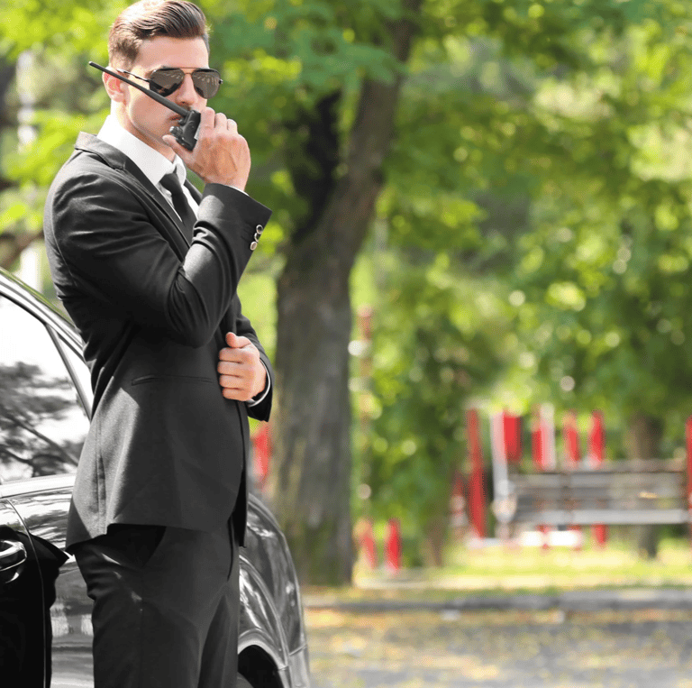Force Prévention Sécurité – Agent de sécurité en costume noir, équipé d'une oreillette et d'un talkie-walkie, assurant la pro
