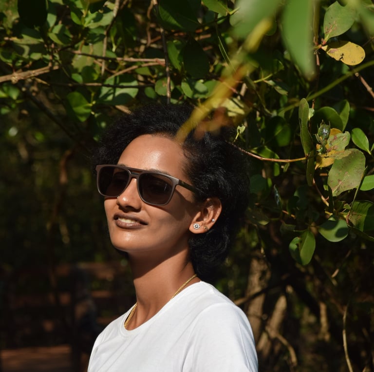 Portrait of Lavanya, the founder of VYAL FINDS, wearing sunglasses in a bright, natural outdoor setting