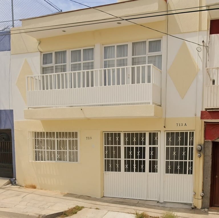 a building with a white and yellow building with a red door