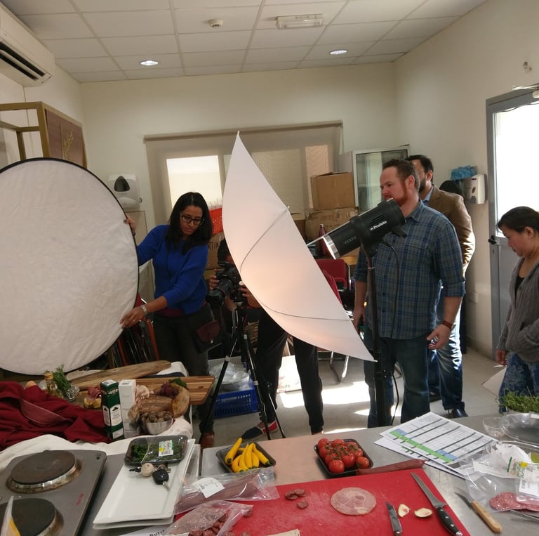 a group of people standing around a table with a camera