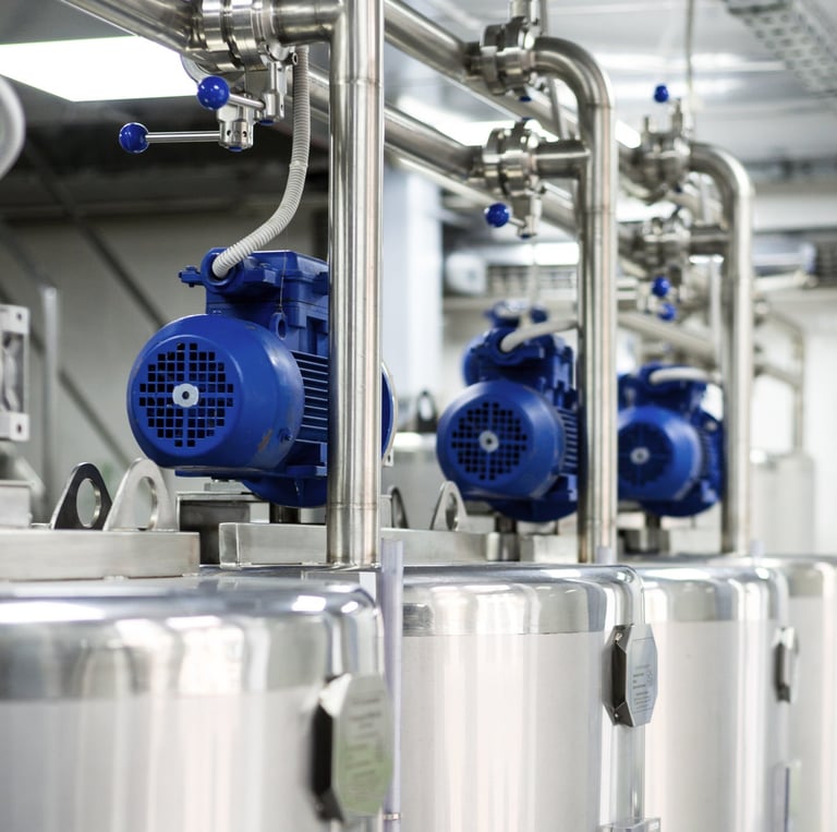 Tanques industriales de fermentación de acero inoxidable con motores eléctricos azules en una cervec