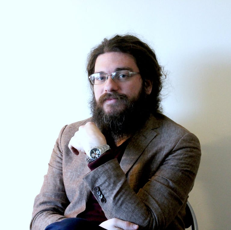 a man with a beard and glasses on a chair