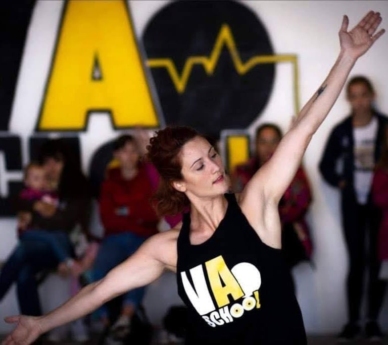 une professeur donnant un cours de danse en débardeur noir