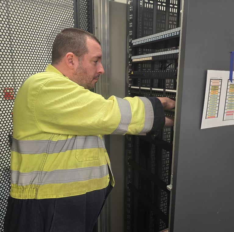 Sam Murphy, Managing Director of Easy Spark Ltd, installing fibre optic and CAT6 patch panels.