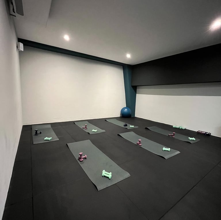 Sala fitness della palestra Move 2 Grow a Milano con tappetini, manubri e attrezzature per allenamenti di gruppo.