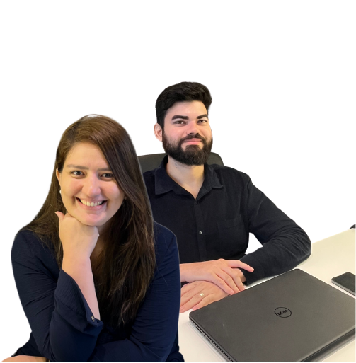 a man and woman sitting at a table with laptops