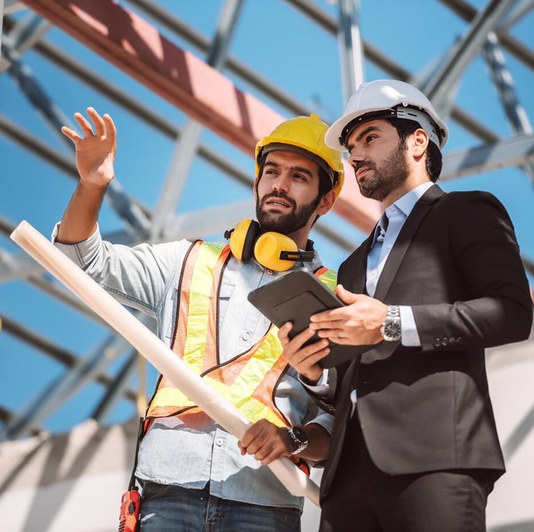 Dois profissionais de Engenharia e Regularização de Obras analisando uma construção civil