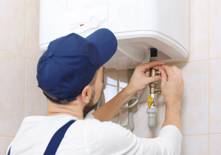 A plumber installing a water heater in a bathroom