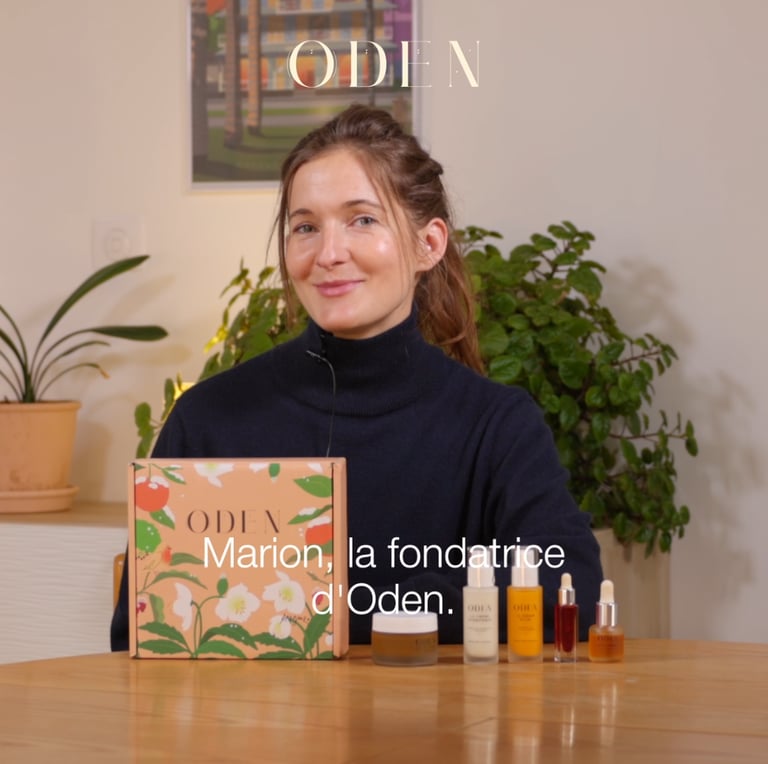 a woman sitting at a table with a box of perfumes