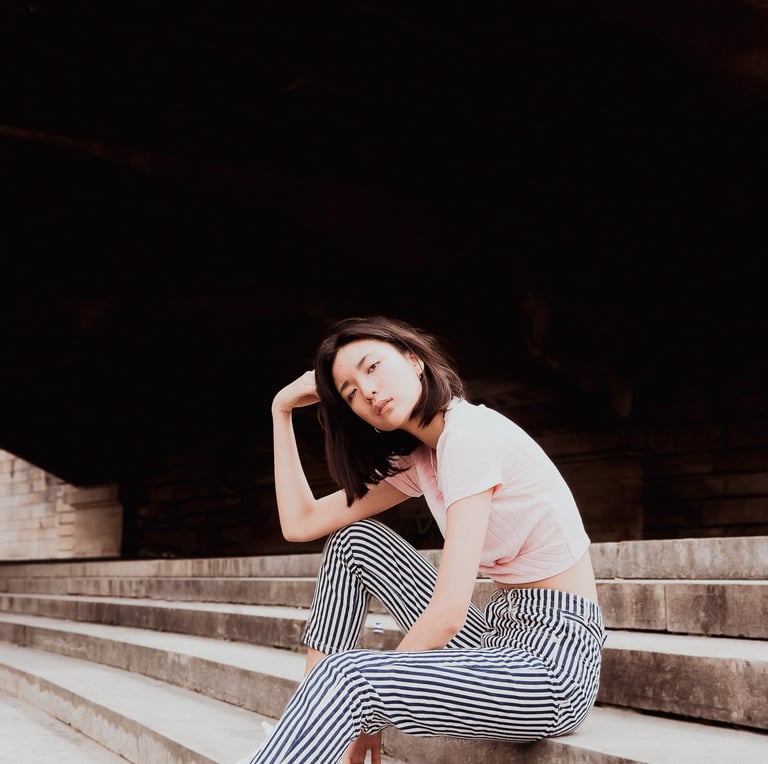 portrait de femme assises sur des escaliers couleurs douces