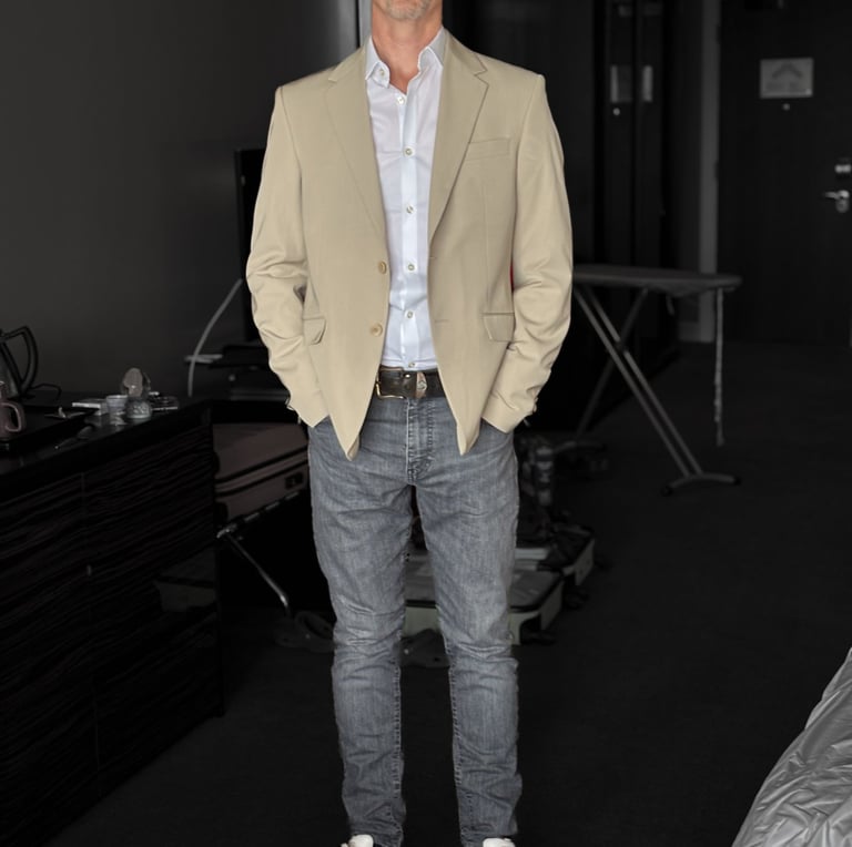 Portrait photo of Mark Murfitt wearing a cream colored jacked, white shirt, black jeans