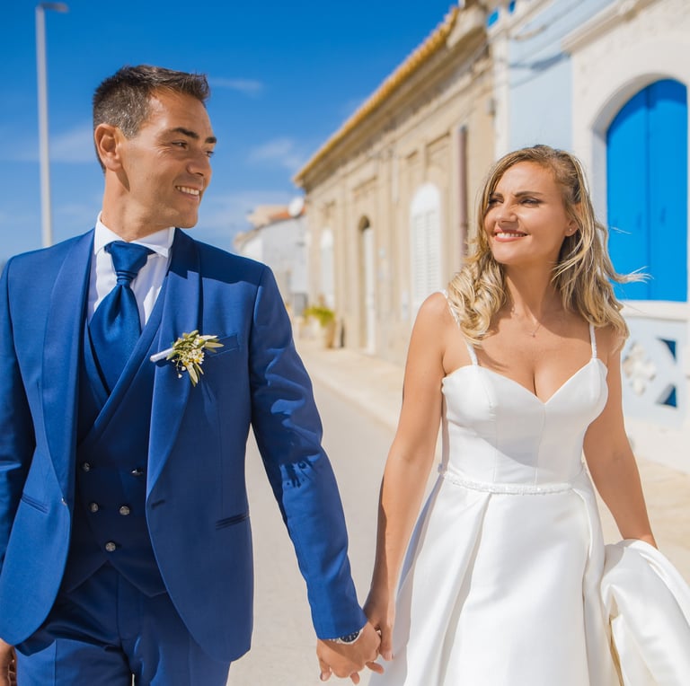 sposo e sposa che passeggiano al mare