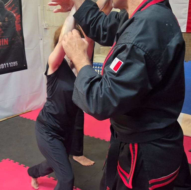A martial arts instructor demonstrates a knife defense technique during a self-defense class.