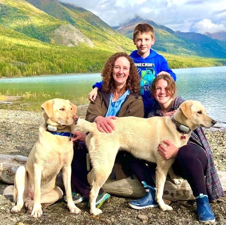 Dr. Brooks and her two kids and dogs at lake with mountains