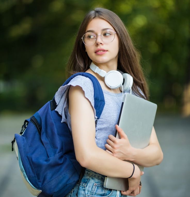 a woman with headphones and a backpacker