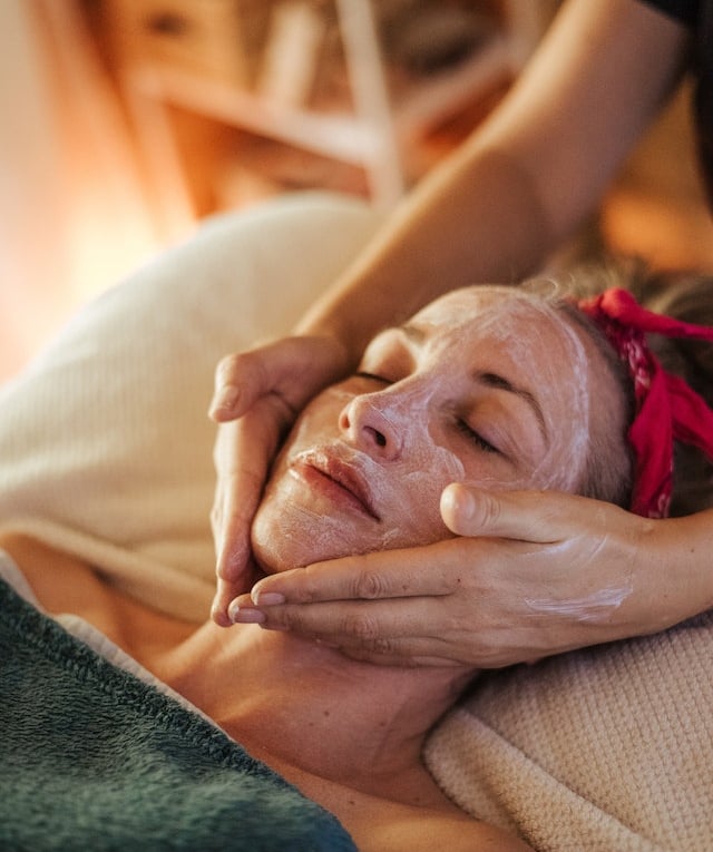 a woman getting a facial mask with a facial mask