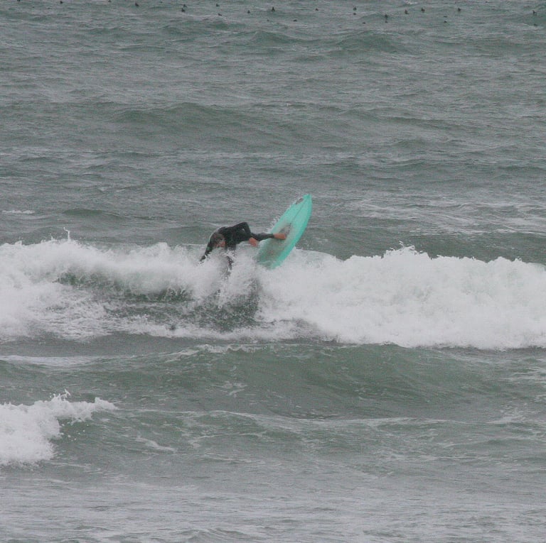 Surfer on green board performing a vertical snap