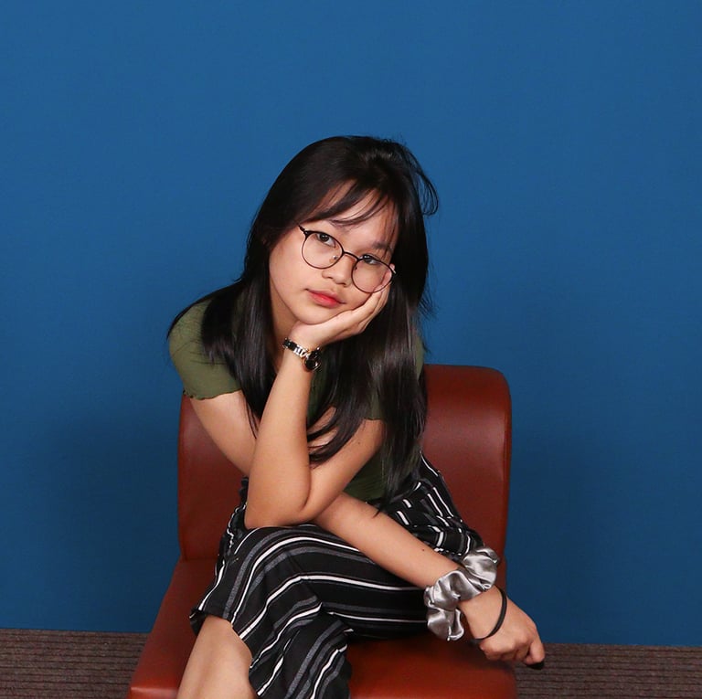 Girl having a self-shoot on blue background