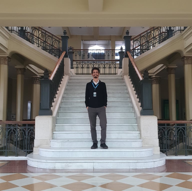 Médico neurologista em pé no saguão da faculdade de medicina da USP.