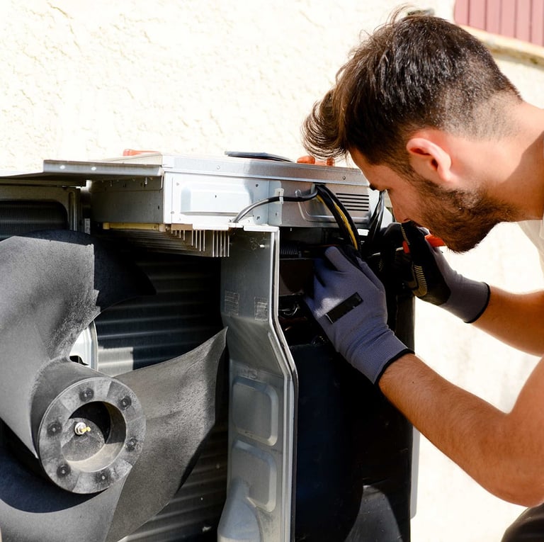 An AC technician wearing protective gloves while checking electrical components of an air conditioning unit, ensuring safety 