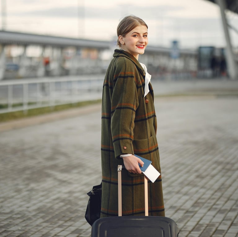 a woman in a coat and hat with a suitcase