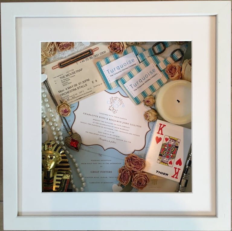 memory box full of wedding items and candle, playing card and preserved wedding flowers flowers