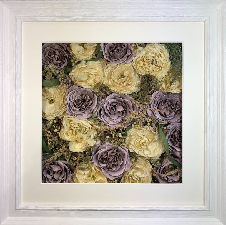 an ivory and lilac flower wall style preserved wedding bouquet in a frame