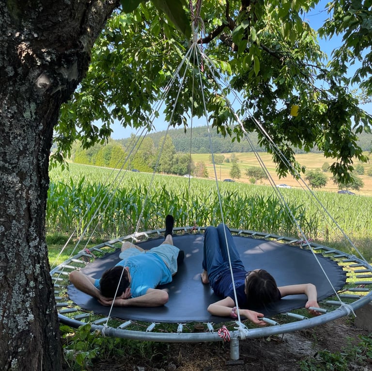 a man and woman laying on a hanging bed
