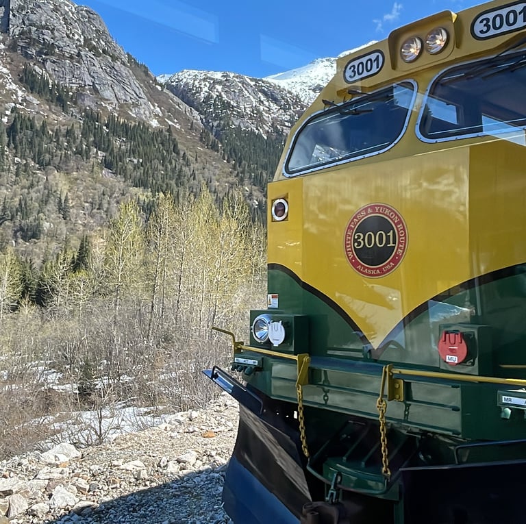 a train is shown in the mountains of Alaska