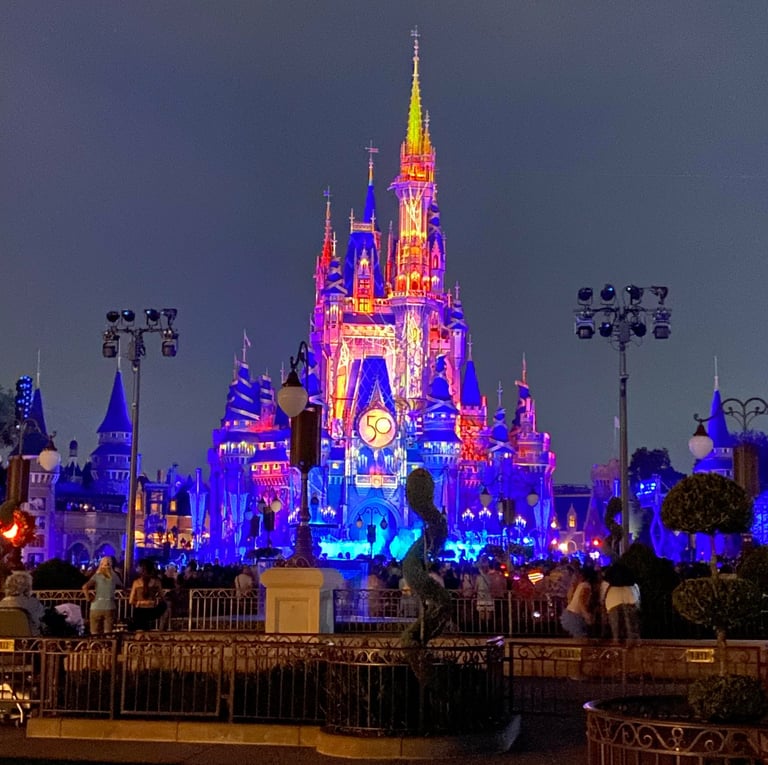 Cinderella Castle at Magic Kingdom Park is lit up at night.