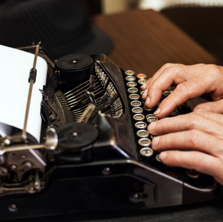 Se ven las manos de una persona escribiendo en una máquina de escribir