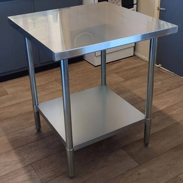 Commercial stainless steel work table available for table hire with solid under shelf and adjustable legs.