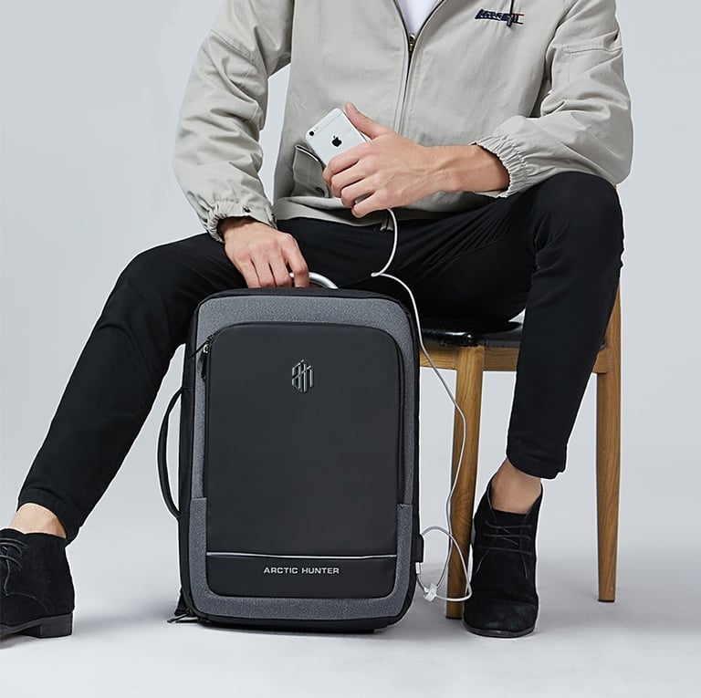 Homme qui recharge son téléphone avec son sac à dos acheté sur urban-bag.fr
