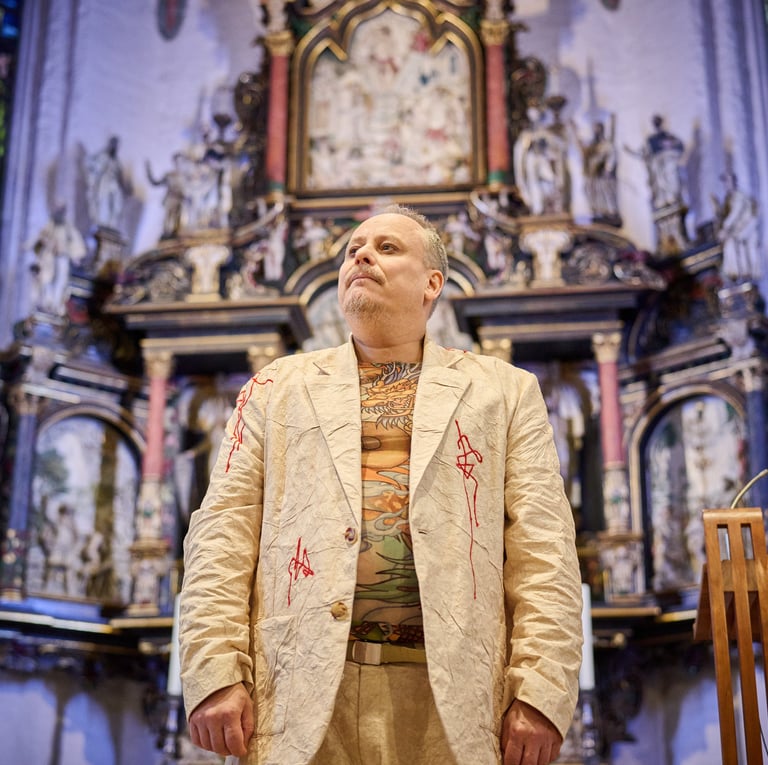 Ein Mann in hellem Anzug steht vor einem Kirchenaltar und schaut entschlossen.