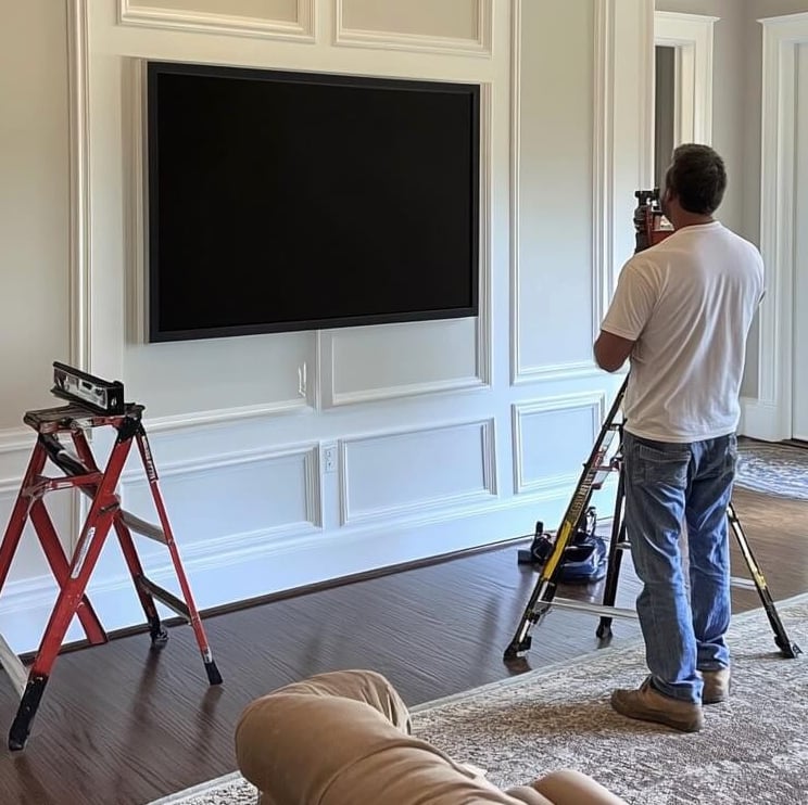 tv installer mounting tv on wood panel wall