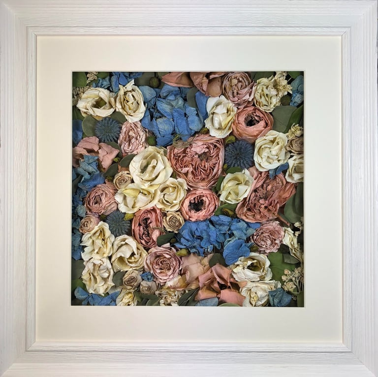 a pink and blue flower wall style preserved wedding bouquet in a frame