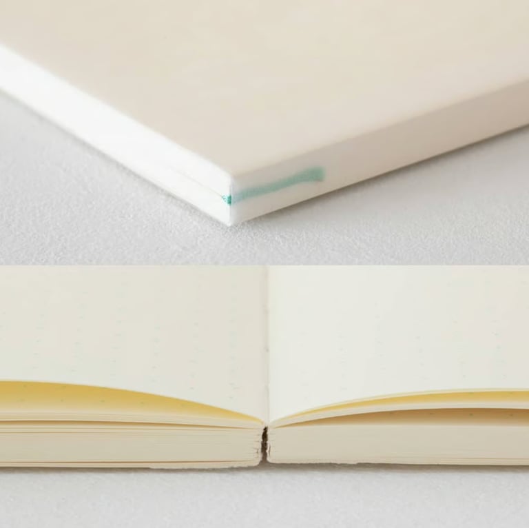 Close-up of a minimalist cream dot grid notebook with high-quality thick paper for journaling and sketching.