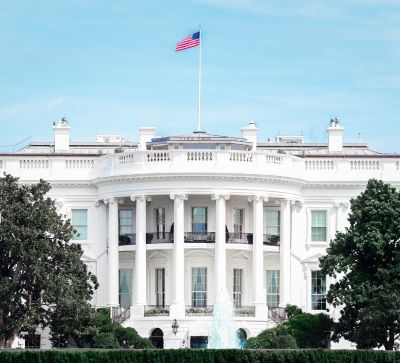 white house - a large white house with a flag on top of it