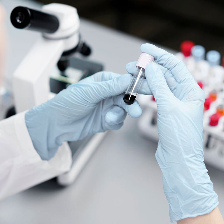 Cientista com luvas azuis segurando uma amostra de sangue.