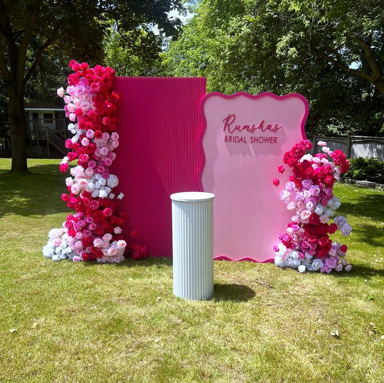 a hot pink and white floral bacldrop for a bridal shower outside