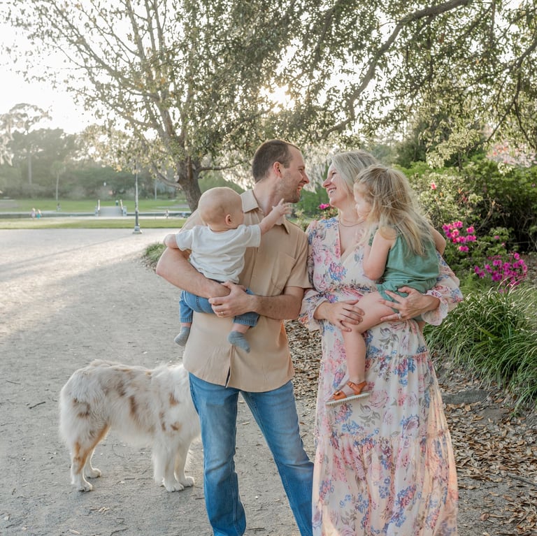Emily with her husband, two kids with her Australian shepherd in the background..