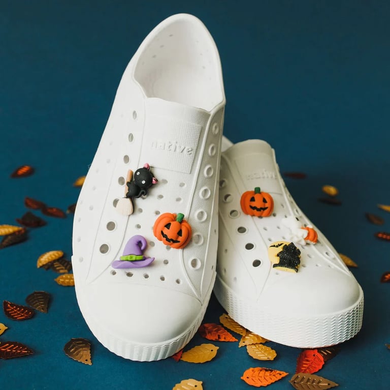 a pair of white shoes with halloween decorations on them