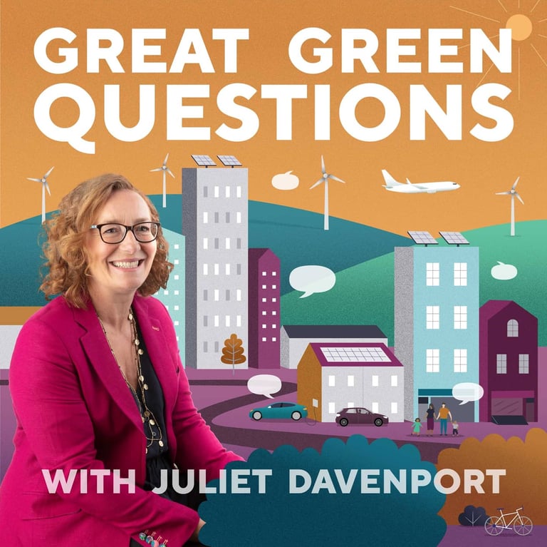 Woman sits in front of an illustrated scene of colourful a town with hills and wind turbines.