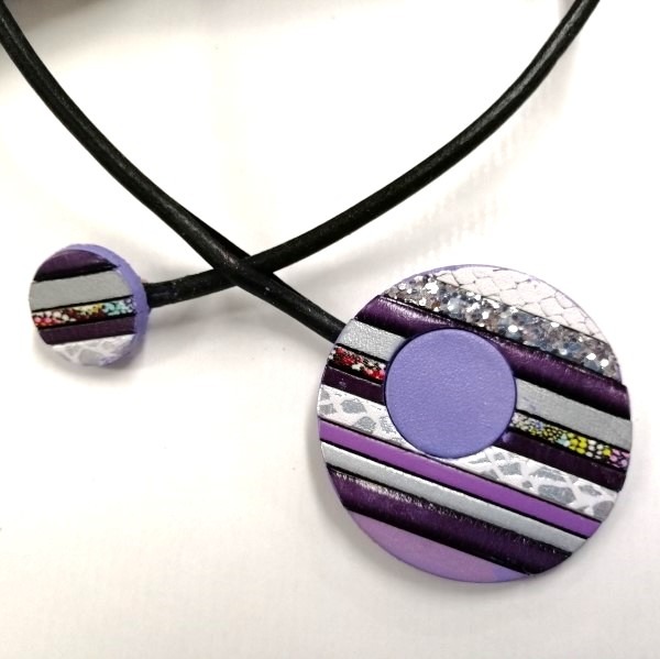 Handmade purple polymer clay necklace with striped disc pendants on a black cord.