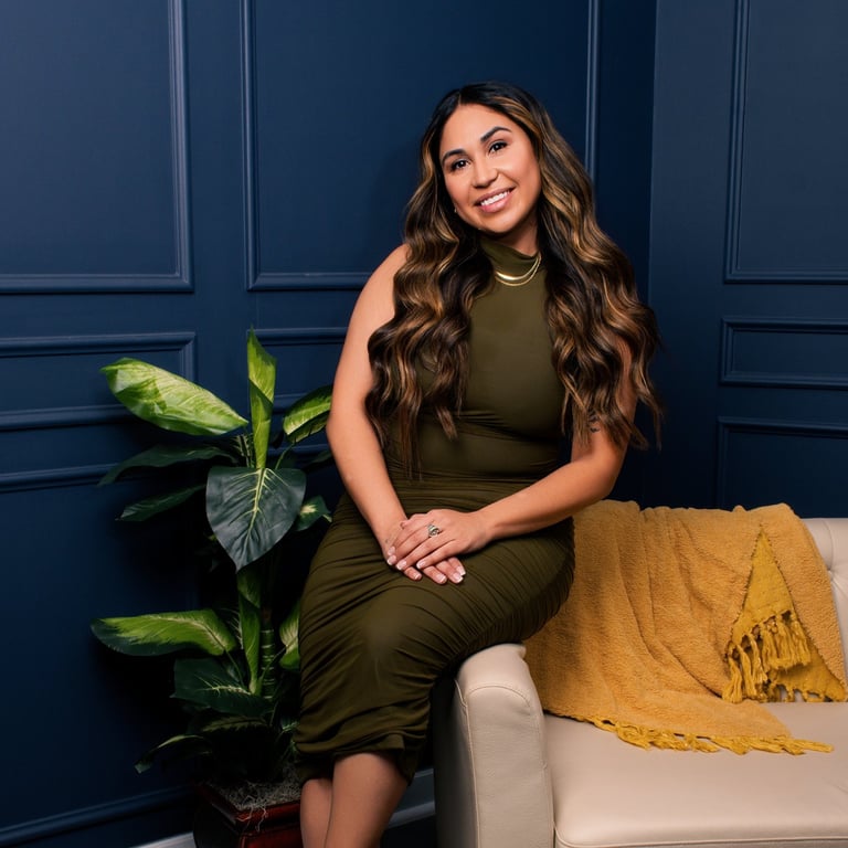 Beautiful Latina sitting on the edge of a comfortable sofa while smiling and crossing her hands