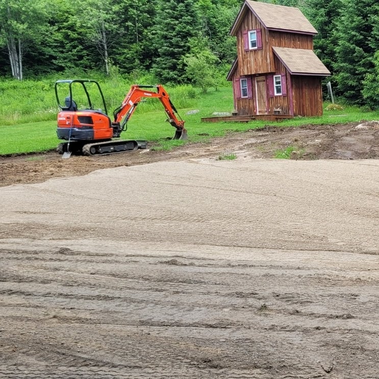 excavator and house on cleared land